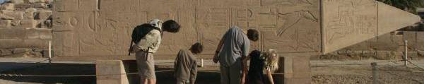 Ouders met kinderen kijkend naar een obelisk van Hatsjepsut in Karnak tempel